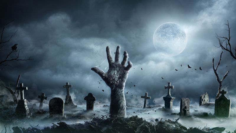 Immagine di un cimitero con una mano di zombie che si sta risvegliando
