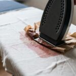Come togliere le macchie di cera di candela dalla tovaglia usando un foglio di carta assorbente e il ferro