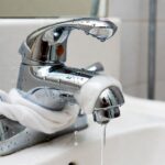 Il trucco del calzino bagnato con aceto di alcol per lucidare i rubinetti del bagno in un attimo