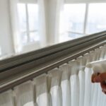 Il trucco dello spray per vetri per far scorrere di nuovo le tende inceppate sui binari metallici